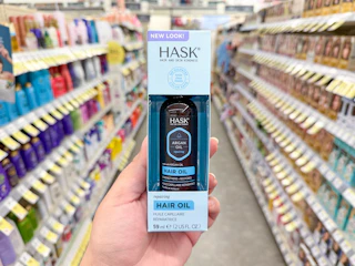 hand holding hask hair oil in walgreens