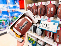hand holding a franklin sports football in front of a target shelf