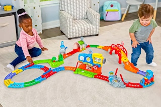 Lifestyle image of two children playing with the VTech My First Motorized Train Set