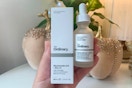 Hand holding The Ordinary skin care products 