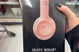 a woman holding a pair of pink Beats Solo 3 by Dr. Dre at Target