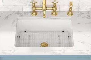 Lifestyle image of the Sarial porcelain ceramic skin with gold finishes and bottom grate in ktichen setting