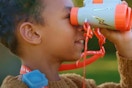 a boy using toy binoculars