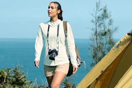 woman wearing white sun protection hoodie at campsite