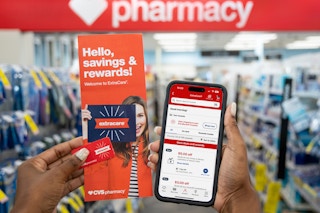 someone holding up a cvs extracare pamphlet and phone showing the CVS app