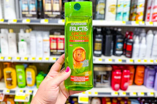 hand holding a bottle of garner fructis shampoo