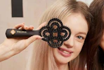 a girl holding a hair brush