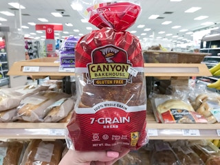 hand holding a bag of canyon bakehouse gluten free bread at target