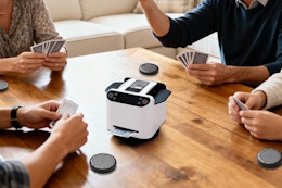 Family sitting around a table using the Eolzzi Pro 2-in-1 Automatic Card Shuffler & Dealer Machine playing cards.