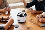 Family sitting around a table using the Eolzzi Pro 2-in-1 Automatic Card Shuffler & Dealer Machine playing cards.