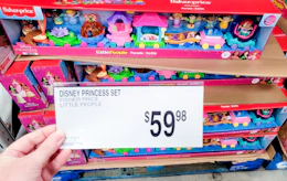 hand holding price signage in front of fisher price toy set
