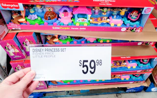 hand holding price signage in front of fisher price toy set