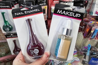 person holding a bottle of maybelline nail polish and a jar of foundation