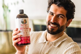 a person holding a brown glass bottle of liquid vitamins