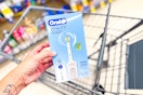 person holding an oral-b electric toothbrush over a cart