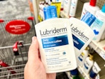 person holding 2 bottles of lubriderm lotion