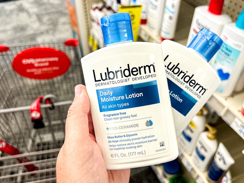 person holding 2 bottles of lubriderm lotion