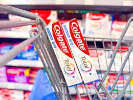 two boxes of Colgate Total toothpaste in a Walmart cart