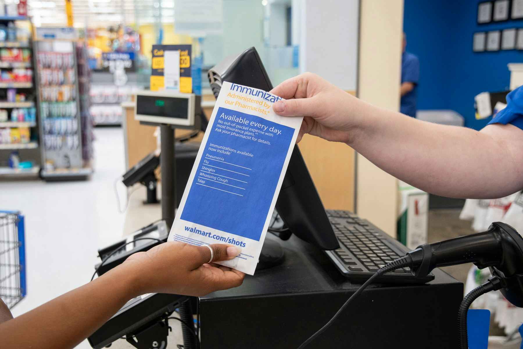 Woman taking a prescription from a Walmart pharmacy employee.
