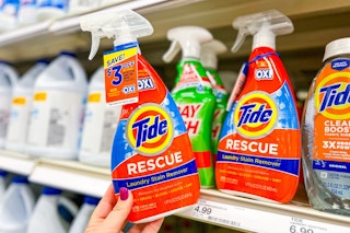hand grabbing a tide laundry stain remover off a target shelf