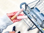 hand holding maybelline serum concealer and lipstick in walgreens