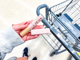 hand holding maybelline serum concealer and lipstick in walgreens