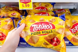 hand holding a bag totinos pizza rolls