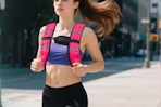 woman running with weighted vest on