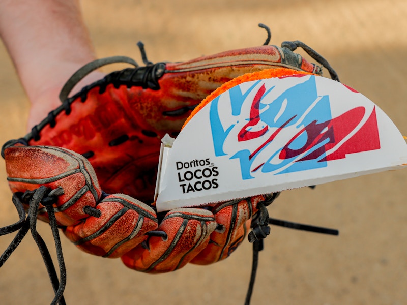 a person holding a taco in their baseball glove