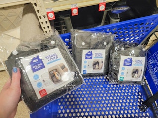 hand holding a kennel cover in front of a cart with kennel covers in it