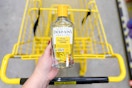 hand holding a bottle of dickinson's toner above a yellow shopping cart