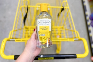 hand holding a bottle of dickinson's toner above a yellow shopping cart