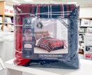 An 8-piece red and blue comforter set on a shelf at Macy's.