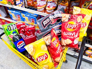 cart full of soda, chips, and pizza