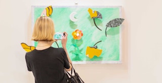 Person photographing installation, Structure of Life by artist Niki De Saint Phalle at the MOMA PS1