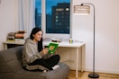woman reading under lamp on couch