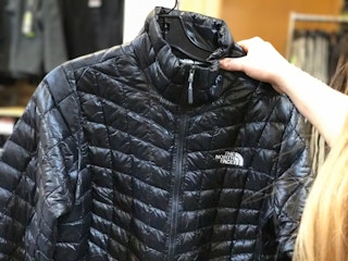 Person holding up a North Face jacket