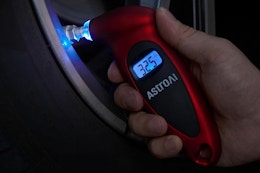 a man using a digital tire pressure gauge on a tire