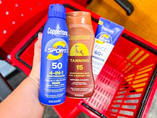 hand holding one Coppertone Sport spray, tanning lotion and face lotion