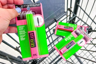 hand placing mascara into shopping cart with two other mascaras