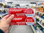 hand holding colgate toothpastes in walgreens