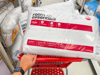 hand pushing cart filled with room-essentials-bed-pillows in target aisle
