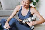 a woman using a massage gun