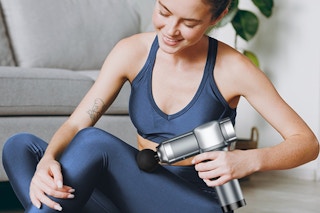 a woman using a massage gun