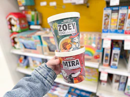 hand holding 2 kpop demon hunters puzzles in front of target shelf