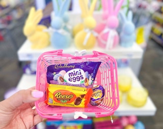 hand holding a basket with Reese's egg, Cadbury creme egg and Mini eggs