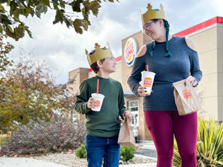 A mom and kid walking out of Burger King with drinks