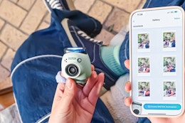 Lifestyle image of Instax Pul Camera held near an iPhone using the Instax app