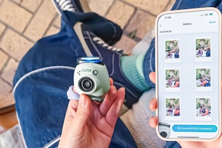 Lifestyle image of Instax Pul Camera held near an iPhone using the Instax app