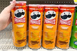 hand holding pringles cheddar cheese chips